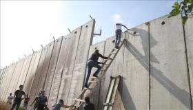 السلالم الخشبية وتسلق الجدار العازل وسيلة الفلسطينيين للوصول إلى المسجد الأقصى